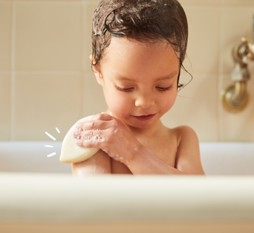 Enfant dans le bain qui se lave avec un shampoing solide Mustela
