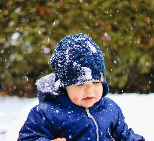 Enfant avec un bonnet sous la neige