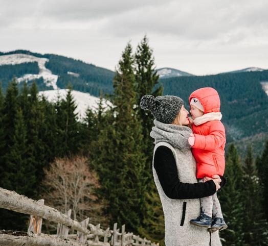 Femme portant un enfant dans les bras à la montagne