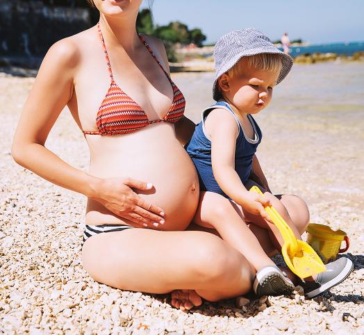 femme enceinte qui porte un enfant au soleil