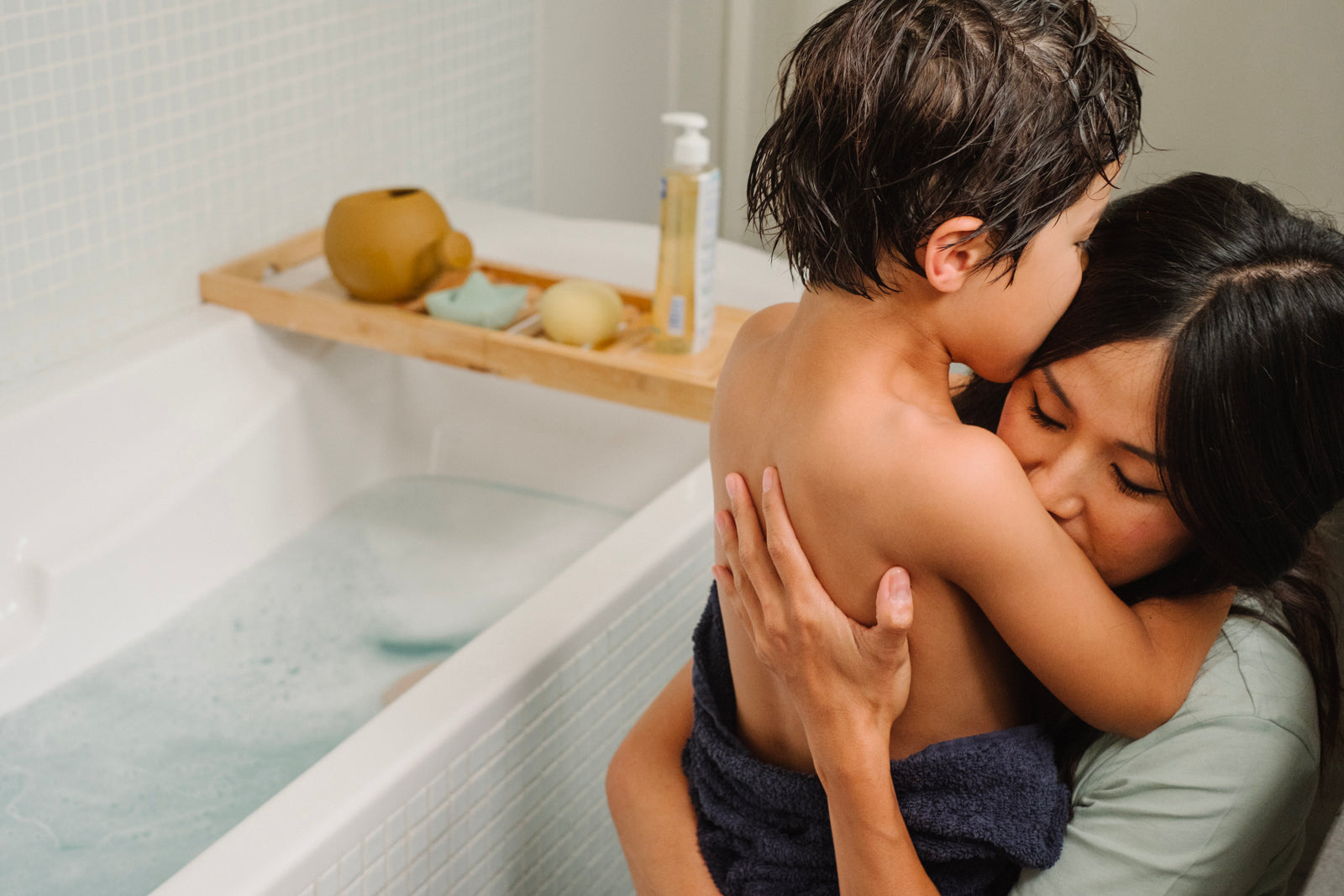 Maman et enfant faisant un calin dans une salle de bain